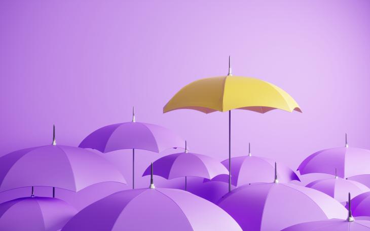 Yellow umbrella in a bunch of purple ones 